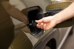 closeup-man-opening-ev-vehicle-inlet-port-attach-electric-cable_482257-130225