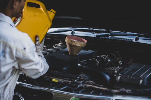close-up-auto-mechanic-hand-pouring-replacing-fresh-oil-into-car-engine-auto-repair-garage-automobile-maintenance-industry-concept_1150-16578
