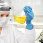 closeup-portrait-female-scientist-holding-conical-tube-with-liquid-solutionn_273609-13631
