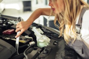 high-angle-woman-repairing-car-engine_23-2148327590
