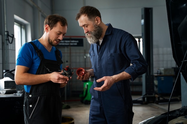 male-mechanics-working-together-car-shop_23-2150376980