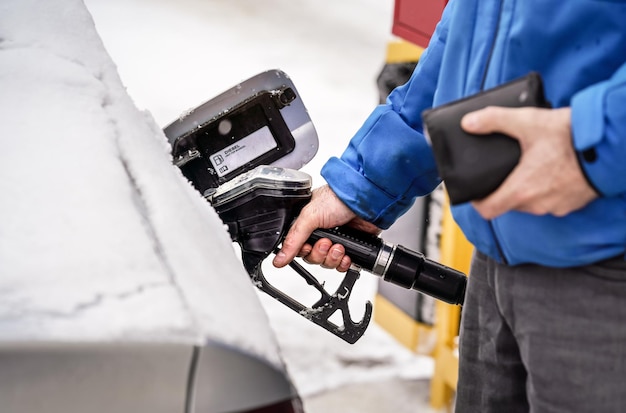 man-holding-fuel-nozzle-filling-gas-tank-diesel-car-covered-with-snow_692357-7896