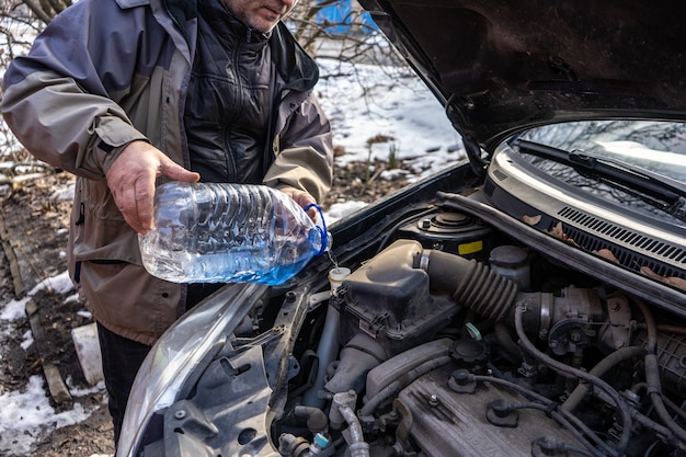 man-pouring-antifreeze-into-special-fluid-tank_298425-539