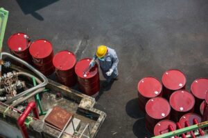 top-view-male-worker-inspection-record-drum-oil-stock-barrels-red-vertical-chemical-industry_478515-4156